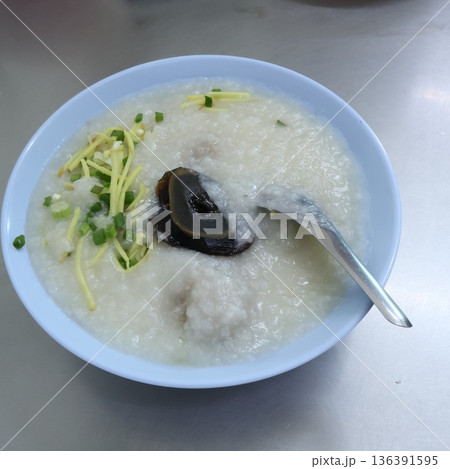 Thai rice porridge or Congee topped with preserved century egg, ginger, and spring onions in a bowl 136391595