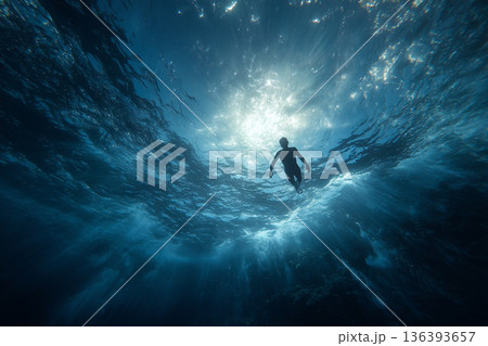 A freediver's perspective: looking up at the shimmering surface, seeing a distant boat and streaks of sunlight far above. A freediver's perspective: looking up at the shimmering surface, seeing a distant boat and streaks of sunlight far above. 136393657