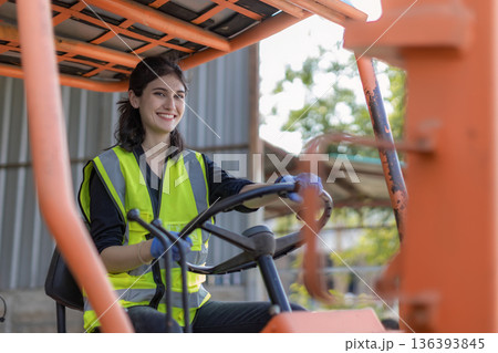 Woman worker at forklift driver happy working in industry factory logistic ship. Woman worker at forklift driver happy working in industry factory logistic ship. 136393845