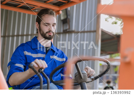 Man worker at forklift driver happy working in industry factory logistic ship.  136393992