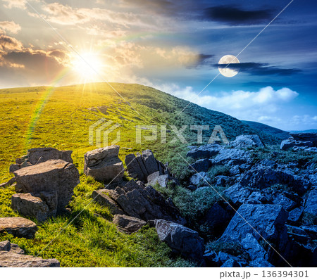 mountain landscape on summer solstice. day and night time change concept. green grass and rocks on hillside with sun and moon at twilight. beautiful view of remote place in alpine environment 136394301