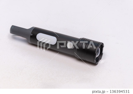 Black multifunction flashlight lies on a light isolated background. 136394531