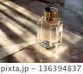 Luxury perfume bottle with golden liquid illuminated by soft light. Premium beauty and fragrance concept, high end branding, fashion concepts, cosmetic advertising and elegant lifestyle visuals. 136394837