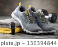 High-quality fitness footwear with smartwatch, towel , and workout gear arranged in a clean modern gym. Running shoes and dumbbell. Training accessories, active lifestyle, motivation, exercise habits. 136394844