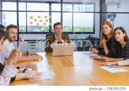 Diverse colleagues gather in brainstorm discuss statistics together. Diverse colleagues gather in brainstorm discuss statistics together. 136395220