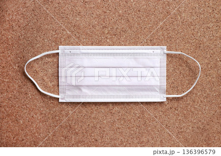 コルク背景に平置きした4層プリーツ不織布マスク 衛生対策の日用品素材 コルク背景に平置きした4層プリーツ不織布マスク 衛生対策の日用品素材 136396579