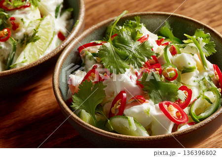 A close-up of freshly prepared "Kokoda" (Fijian ceviche), with coconut cream and lime, garnished with fresh coriander and chili. 136396802