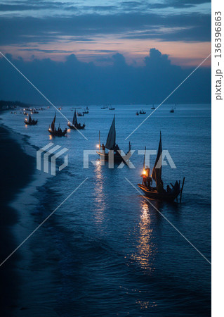 The serene scene of Comorian artisanal fishing boats returning to shore at dusk, their lights twinkling on the horizon. 136396863