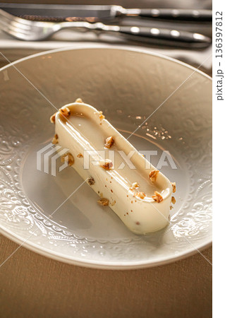 Creamy mousse dessert with nuts on plate 136397812