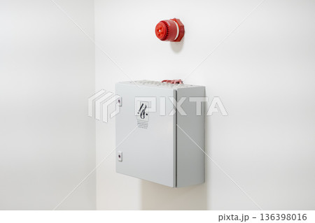 Red fire alarm horn and grey control box with smoke mechanical ventilation label, signifying crucial building safety and modern emergency system Red fire alarm horn and grey control box with smoke mechanical ventilation label, signifying crucial building safety and modern emergency system 136398016