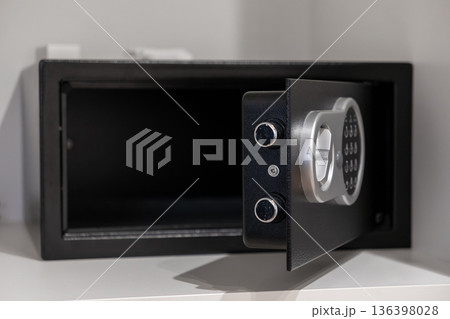 Empty open black electronic safe with a digital keypad and silver handle, representing secure storage for valuables in home or hotel environments 136398028