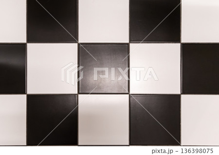 Classic checkerboard pattern with alternating black and white square tiles, creating a versatile geometric background for modern interior design projects Classic checkerboard pattern with alternating black and white square tiles, creating a versatile geometric background for modern interior design projects 136398075