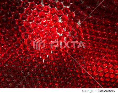 Abstract pattern of illuminated red glass bottle bottoms forms a vibrant, textured background, ideal for beverage concepts or sustainable design 136398093