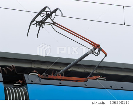 Train pantograph extended upward for crucial electrical power collection from overhead lines, vital for modern public railway system operation 136398113
