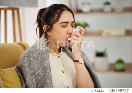Sick, breathing and woman with a pump for asthma, medical emergency or spraying air into mouth. House, covid and a young girl with risk for healthcare, lung support or inhaler on the sofa in her home 136399767