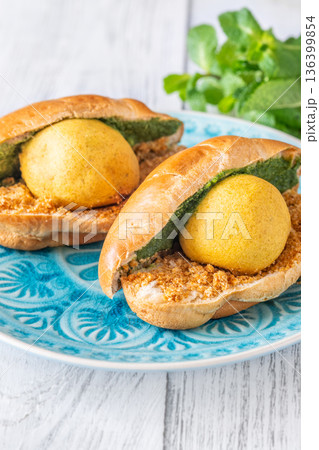 Vada Pav Indian street food served on blue plate in bright overhead composition 136399854