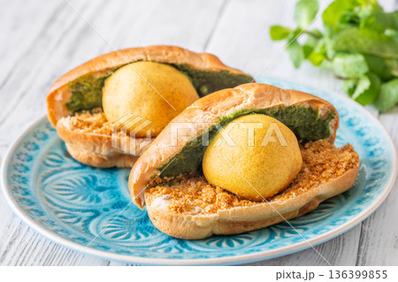 Vada Pav Indian street food served on blue plate in bright overhead composition 136399855