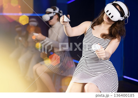 Girls using virtual reality glasses - girlfriends having fun with vr headset Girls using virtual reality glasses - girlfriends having fun with vr headset 136400185