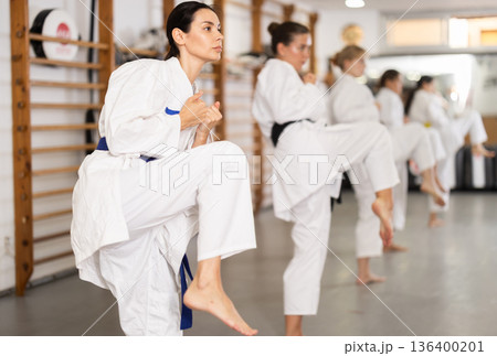 Women students repeat position and perform sequence of punches and painful techniques kata 136400201