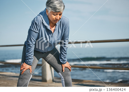 Senior, exercise and tired woman at the beach on break from training, workout or morning cardio run in nature. Sports, fatigue and elderly female runner stop to breathe on ocean workout or fitness Senior, exercise and tired woman at the beach on break from training, workout or morning cardio run in nature. Sports, fatigue and elderly female runner stop to breathe on ocean workout or fitness 136400424