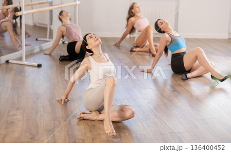 Young woman practicing vogue dance moves on floor at group class 136400452