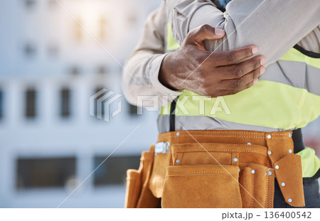 Hand, elbow and pain with a construction worker on a building site, holding a joint injury while working. Risk or problem, emergency and accident with engineer feeling arm ache during a project 136400542