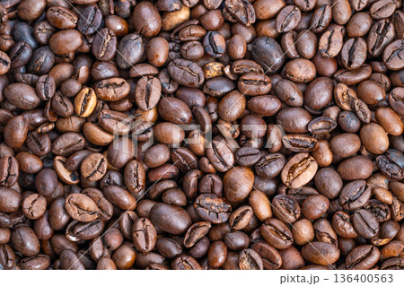 Roasted coffee with natural shine, Sustainable farm sourced beans with uneven color pattern, Handpicked single origin coffee beans showcasing natural variation and rich aroma Roasted coffee with natural shine, Sustainable farm sourced beans with uneven color pattern, Handpicked single origin coffee beans showcasing natural variation and rich aroma 136400563