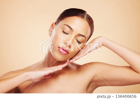Face, calm or woman with natural beauty in studio isolated on brown background for wellness or glow. Skin care shine, hands or zen Brazilian girl model with self love, eyes closed or facial cosmetics 136400656