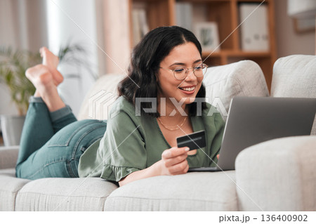 Credit card, computer and woman for home online shopping, e learning and fintech payment on sofa. Relax, student loan and person on laptop banking, study subscription or website transaction on couch 136400902