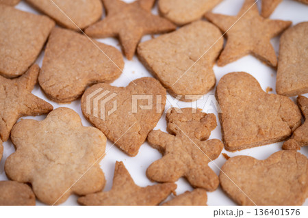 Cozy baking moments, Comforting kitchen setting with charming baked goods, Tranquil scene of handcrafted cookies adorned with hearts and flower shapes on white surface 136401576