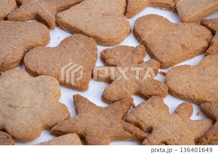 Closeup of variety of sugar cookies shaped as hearts and stars, An overhead shot showcasing assortment of decorated cookies with heart and star shapes in warm hues 136401649