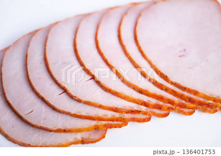 Ham slices arranged for presentation. Slices of ham neatly arranged for product display. Perfectly aligned ham pieces prepared for packaging and ecommerce product images 136401753