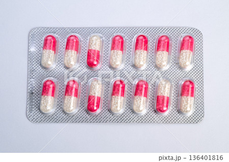 Glossy capsules arranged neatly. Medicinal capsules in structured blister pack. Pharmacy style presentation of shiny capsules in meticulously arranged blister pack 136401816