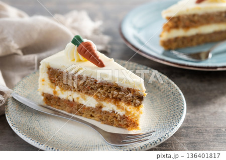Carrot cake slice with cream cheese frosting on wooden table 136401817