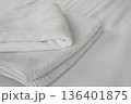 Clean folded white towels on hotel bed in bright room 136401875