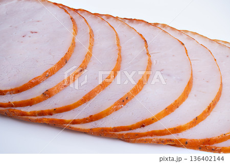 Diagonally arranged moist turkey slices under studio lighting. Thinly sliced smoked turkey breast arranged diagonally with visible spices and moist texture under studio lighting 136402144