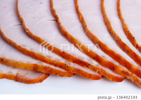 Artful sliced meat. Expertly cut roasted meat layers. Slices revealing butcher skills and seasoning details. Showcasing professional slicing and seasoned edges of roast meat 136402193