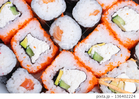 Sushi night comfort. Silent night with soothing lighting and delicious sushi bites. Relaxing evening scene featuring sushi with creamy filling and gentle warm illumination 136402224