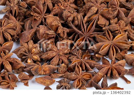 Spicy seed cluster. Detailed view of dense dried anise pods and seeds. Textured image showcasing clustered dried star anise with earthy tones for herbal packaging Spicy seed cluster. Detailed view of dense dried anise pods and seeds. Textured image showcasing clustered dried star anise with earthy tones for herbal packaging 136402392