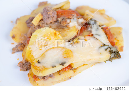 Creamy cheesy sausage casserole. Savory baked potato dish with sausage and cheese. Hearty cheese and sausage baked dish featuring creamy potatoes and fresh tomato garnish Creamy cheesy sausage casserole. Savory baked potato dish with sausage and cheese. Hearty cheese and sausage baked dish featuring creamy potatoes and fresh tomato garnish 136402422