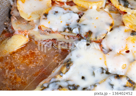 Elegant layered pizza. Sophisticated potato pizza topped with herbs and creamy ricotta cheese. Luxurious layered potato dish enriched with fresh herbs and smooth ricotta cheese 136402452