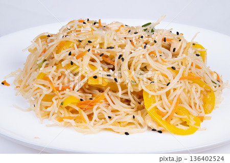 Deconstructed rice vermicelli with yellow pepper, sesame seeds and microherb garnish, delicate balance of savory and fresh notes, elegant restaurant plating under soft spotlight Deconstructed rice vermicelli with yellow pepper, sesame seeds and microherb garnish, delicate balance of savory and fresh notes, elegant restaurant plating under soft spotlight 136402524