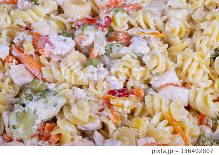 Vivid pasta dish captured overhead. Brightly colored pasta garnished with fresh vegetables. Overhead shot showing lively pasta with seasonal vegetable decorations Vivid pasta dish captured overhead. Brightly colored pasta garnished with fresh vegetables. Overhead shot showing lively pasta with seasonal vegetable decorations 136402807