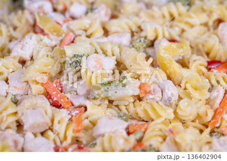 Detailed view of spiral pasta coated with dressing and colorful vegetables. Vivid image showcasing creamy rotini with peas carrots corn and chicken in fine detail Detailed view of spiral pasta coated with dressing and colorful vegetables. Vivid image showcasing creamy rotini with peas carrots corn and chicken in fine detail 136402904