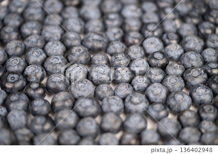 Heaped summer blueberries evoking harvest season and abundance, warm highlights, subtle imperfections, rustic mood ideal for seasonal campaigns and farm branding 136402948