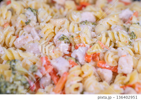 Warm family meal. Comforting comal of pasta with assorted vegetables for sharing. Large familystyle serving of savory rotini mixed with fresh vegetables ideal for gatherings 136402951