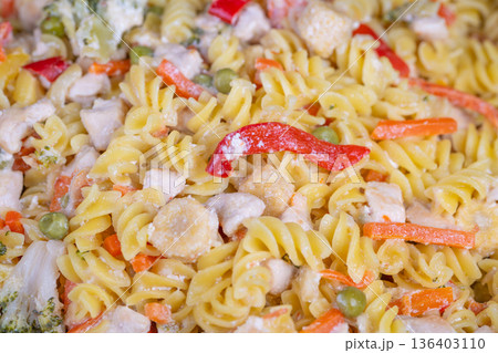 Magnified view of fusilli with colorful vegetable toppings and cheese. Macro shot showcasing fusilli pasta intertwined with vegetables and sprinkled cheese topping Magnified view of fusilli with colorful vegetable toppings and cheese. Macro shot showcasing fusilli pasta intertwined with vegetables and sprinkled cheese topping 136403110