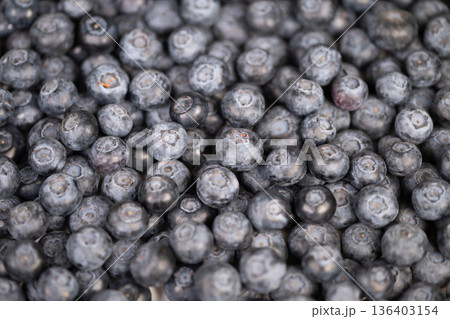 Uniform blueberry textured background creation. Repeating blueberry motif for packaging and web visuals. Vibrant blue blueberries arranged for seamless pattern use in design Uniform blueberry textured background creation. Repeating blueberry motif for packaging and web visuals. Vibrant blue blueberries arranged for seamless pattern use in design 136403154