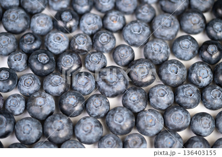 Fresh organic blueberries. Farmfresh blueberries with imperfections. Authentic organic blueberries featuring visible imperfections and wholesome natural color scheme 136403155