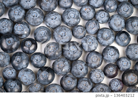 Ripe organic blueberry harvest closeup, matte powdery skin and varied sizes suggest fresh pick from farm, rustic mood suitable for farmers market and seasonal produce imagery Ripe organic blueberry harvest closeup, matte powdery skin and varied sizes suggest fresh pick from farm, rustic mood suitable for farmers market and seasonal produce imagery 136403212